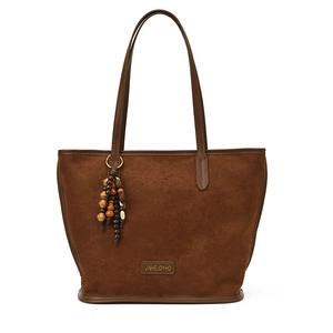 Sac fourre-tout en daim marron rétro avec pendentif en perles sur fond blanc immaculé