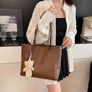 Brown lychee leather tote bag with cute plush bear pendant, stylish commuter shoulder bag