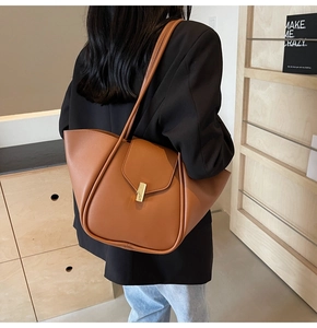 Borsa tote in pelle marrone indossata da una modella per mostrare le dimensioni reali