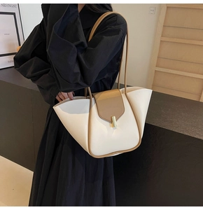 Dettaglio borsa tote bicolore in tessuto beige con pelle marrone e fibbia dorata
