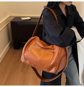 Caramel woven tote bag shown on model with shoulder strap for travel and fitness