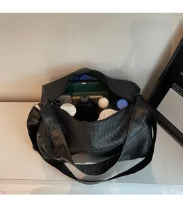 Interior view of black woven travel bag showing large capacity for laptops and daily items