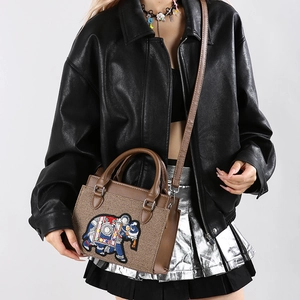 Sac bandoulière vintage avec broderie éléphant et perles porté par un mannequin