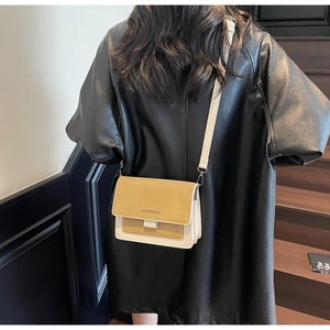 Model wearing a yellow and beige crossbody bag with a matte finish and fashion text