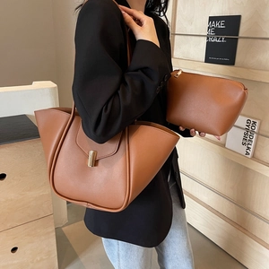 Borsa tote retrò in pelle marrone con pochette coordinata su scaffale di legno