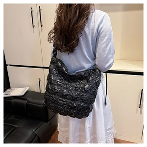Dettaglio della grande borsa a nuvola trapuntata nera che mostra texture e vestibilità