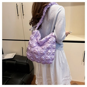Dettaglio della borsa trapuntata lilla con tracolla a balze e morbida texture puffy