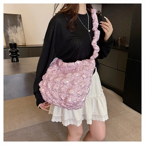 Dettaglio borsa a sbuffo rosa trapuntata con tracolla a volant e texture metallica