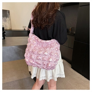 Dettaglio della borsa nuvola rosa chiaro con trama 3D e tracolla con nodo decorativo
