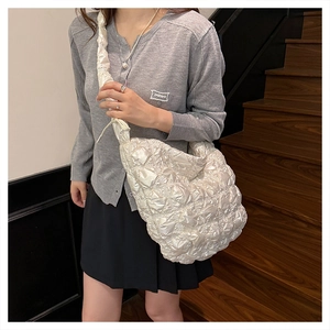 Dettaglio della borsa a nuvola arricciata bianco perla con texture trapuntata e tracolla larga