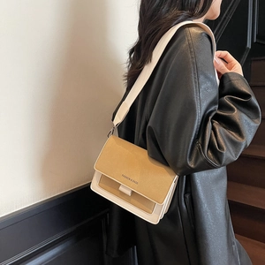 Retro colorblock crossbody bag with yellow flap and cream wide strap worn on a leather jacket