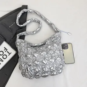 Metallic silver quilted cloud tote bag shown with a smartphone for size comparison