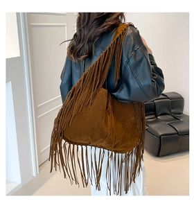 Détail d'un sac hobo en daim marron avec de longues franges et un style de rue bohème