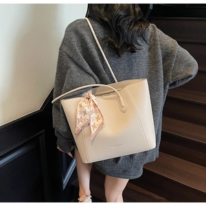 Detail of cream tote bag featuring lychee grain leather and pink houndstooth silk scarf