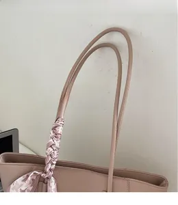 Detail of lychee pattern leather tote with long straps and decorative silk scarf