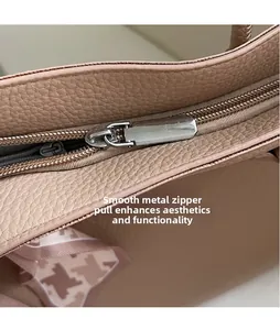 Detail of smooth metal zipper puller on pebble grain leather tote bag