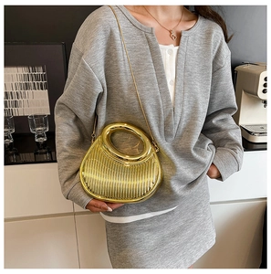 Detail of gold crescent evening bag with vertical texture and metal chain strap