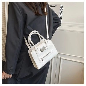 Detail of white mini square handbag with silver hardware and detachable shoulder strap