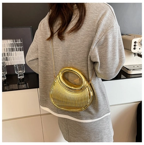 Detailed macro view of the gold textured crescent bag with a metal chain shoulder strap