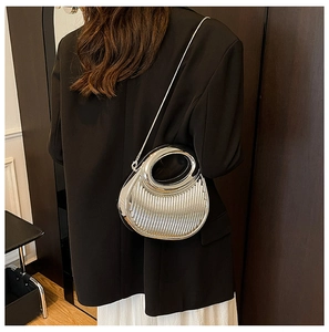 Close-up of silver crescent handbag with vertical pleats and detachable chain strap