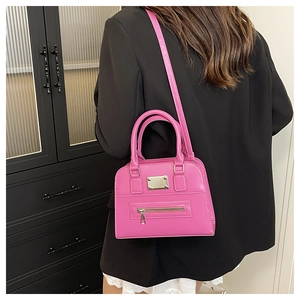Hot pink leather handbag with top handles and shoulder strap shown in a fashion outfit
