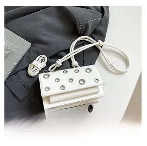 Detail of white leather shoulder bag with rivet cutouts and heart-shaped rope strap