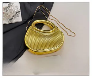 Detailed size comparison of a gold crescent clutch bag next to a smartphone