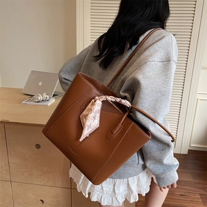 Sac cabas en cuir marron avec foulard en soie présenté dans un cadre décontracté