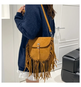 Brown vintage fringe crossbody bag with suede texture and metal buckle on female model