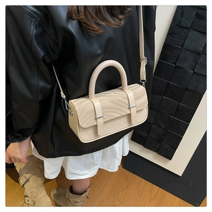Detail of cream box bag showing 3D wave texture and adjustable shoulder strap style
