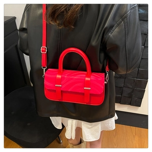 Chic red leather handbag with wave pattern and silver hardware detail in lifestyle shot