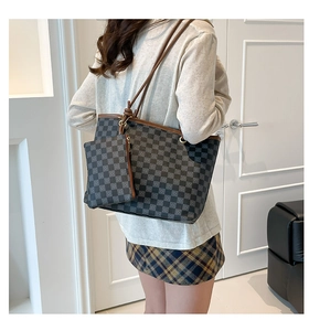 Detail of checkered tote bag with matching pouch shown on shoulder for size scale