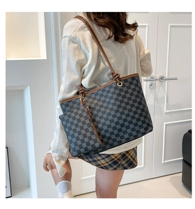 Detail view of large checkered tote bag set with matching pouch and brown leather straps