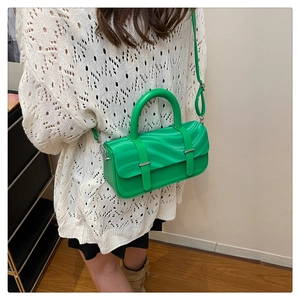 Detail of lime green crossbody bag with textured wavy flap and silver hardware