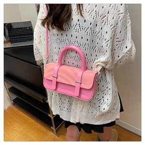 Rear view of a stylish pink crossbody bag with marble pattern flap in a home setting
