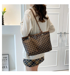 Detail of checkered tote bag set with matching small zipper pouch and leather straps