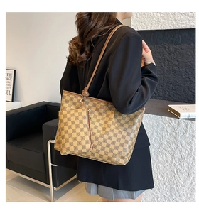 Detail of checkered tote bag with matching zipper pouch on model in a minimalist room