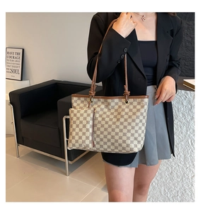 Detail of checkered tote bag and matching pouch set with leather shoulder straps on a model