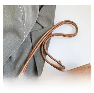 Detail of checkered tote bag with floral patterns and leather knotted handle straps