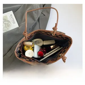 Macro view of vintage checkered tote bag interior filled with daily essentials