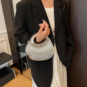 Silver metallic crescent handbag with ring handle and pleated texture for evening events