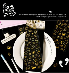 Vue détaillée d'autocollants de chats dorés sur une assiette avec des accessoires de bureau
