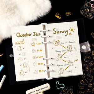 Flat lay of a cat themed PET planner stickers set with gold stamping on black background