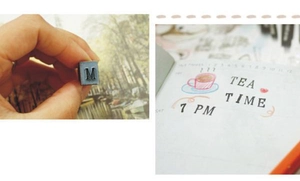 Macro shot of a vintage metal letter stamp showing a clear ink imprint on paper