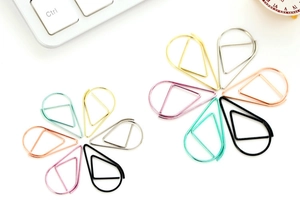 Creative water drop paper clips arranged in flower patterns on a desk with a keyboard