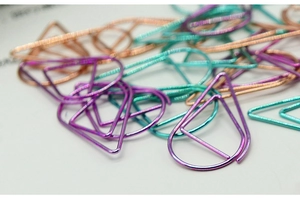 Macro shot of colorful teardrop and triangle metal paperclips with spiral texture details