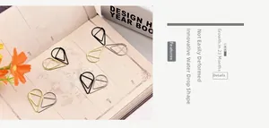 Detailed view of water-drop and heart shaped metal paperclips on a vintage notebook