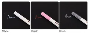 Metallic marker pens showing vibrant white, pink, and grey ink on dark cardstock