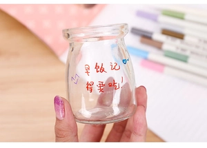 Detail of colorful metallic markers writing on a smooth glass surface with heart patterns