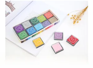 Gros plan de 12 tampons encreurs colorés pour DIY et scrapbooking sur une table blanche